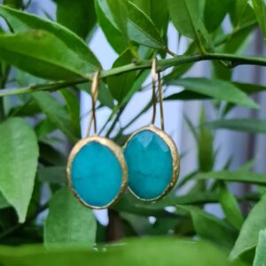 zee blauw kleurige steen met goudkleurige afwerking met haakje voor door het oor